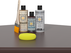 Retique It® Light Wood Wood’n Primer with Java Gel Stain Alternative, satin topcoat, brush, and yellow sponge on a tabletop.