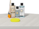 Retique It® Light Wood Wood’n Primer with White Wash Gel Stain Alternative, matte topcoat, and yellow sponge on a white tabletop.