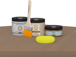 Retique It Barn Wood Kit with Matte Polytique It, Light Wood Wood'n Primer, Barn Wood Gel Stain Alternative, paintbrush, and yellow sponge on a tabletop.