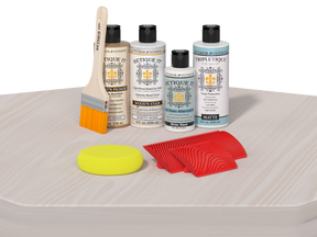Set of car care products including bottles, a brush, and sponges on a white surface.