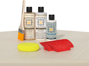 Retique It® Wood'n Finish Kit in White Wash stain, featuring bottles of wood stain and finishing supplies on a tabletop.