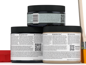 Three jars of wood finish product with labels and a brush on a white background