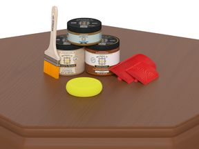 Painting supplies including jars, a brush, a sponge, and red tools on a wooden surface.