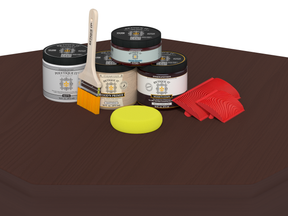 Painting supplies including jars, a brush, a sponge, and a roller on a brown surface.