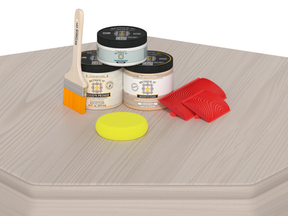 Painting supplies including cans, a brush, and sponges on a textured surface.