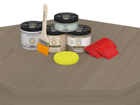 Paint cans, brush, and sponges on a wooden surface