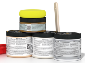 Five jars of body scrub with a yellow lid on a white background