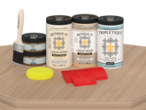 Retique It® Wood'n Finish Kit with four large white oak stain bottles and matte finish, shown on a table surface.