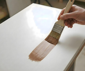 Retique It® Dark Wood Kit primer being brushed onto a wood cabinet door.