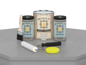 Paint cans and tools on a gray surface with 'Retique It' branding.