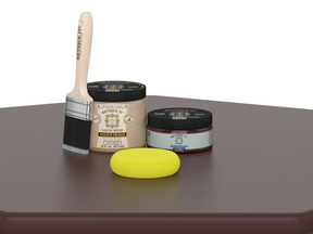 Wood primer and paintbrush on a brown surface with a white background