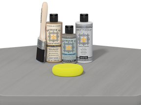 Set of Eticketit wood care products including bottles, a brush, and a yellow sponge on a gray surface.